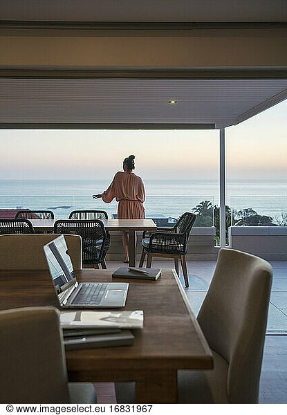 Woman enjoying scenic sunset ocean view from luxury balcony