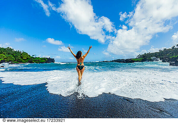 Woman enjoying the sun on one of Maui's black sand beaches  Maui  Hawaii  United States of America  North America