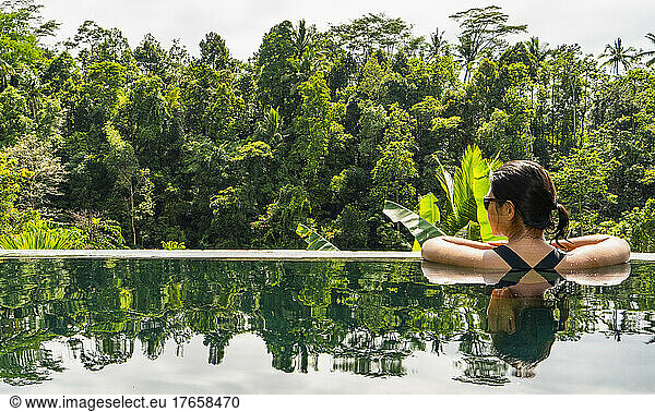 woman enjoying the view from infinity pool at resort in Bali