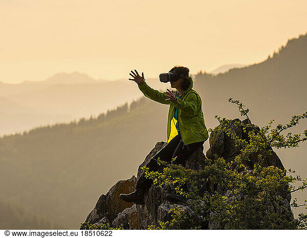 Woman enjoying virtual reality exploration on rocks