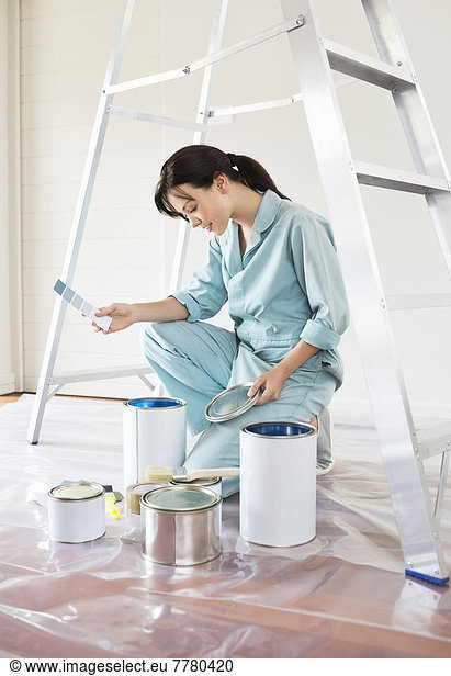 Woman examining paint cans