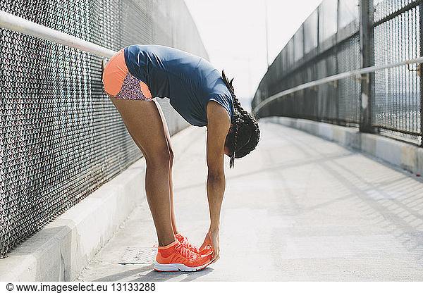 Woman exercising on footbridge