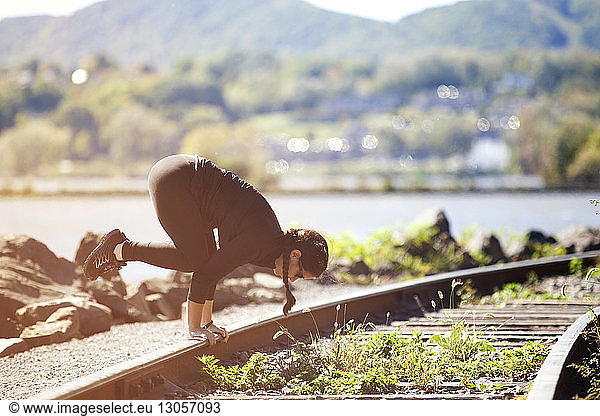 Woman exercising on railroad track