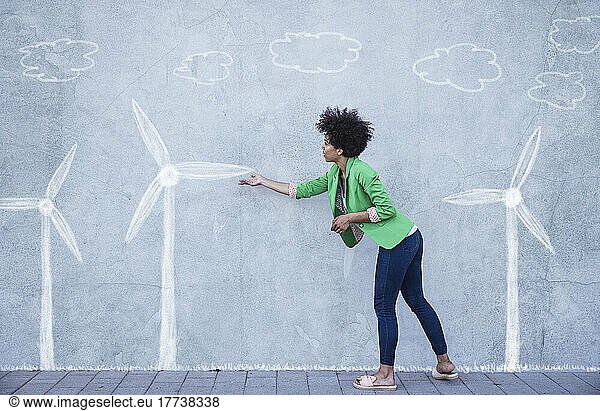 Woman explaining wind turbines painted on wall
