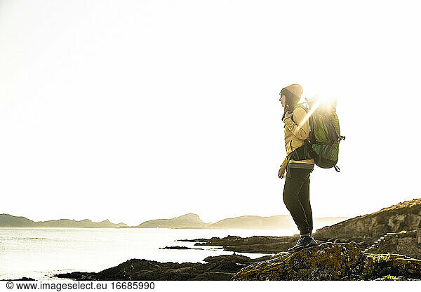 Woman exploring the coastline with backpack