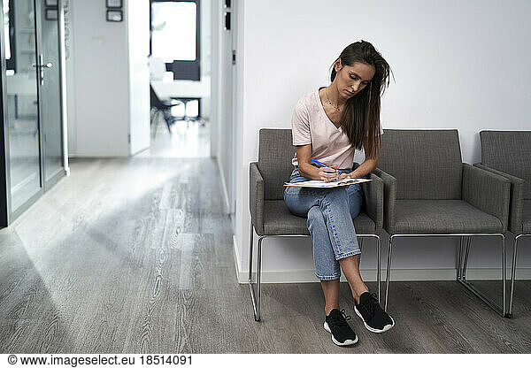 Woman filling form sitting in waiting room