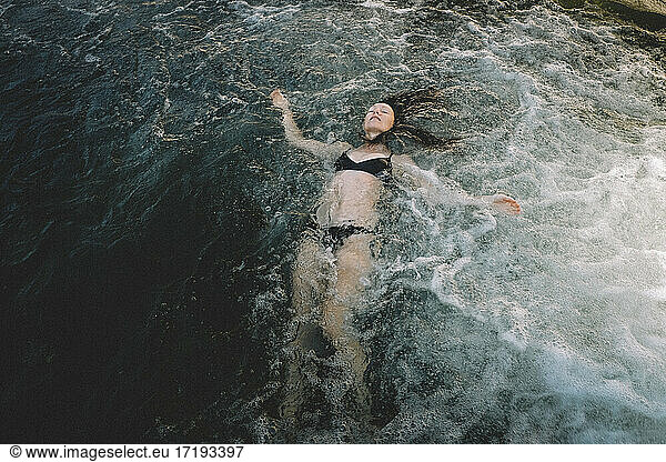 Woman Floating Away in a Dream  Swirling Water. Dawn.