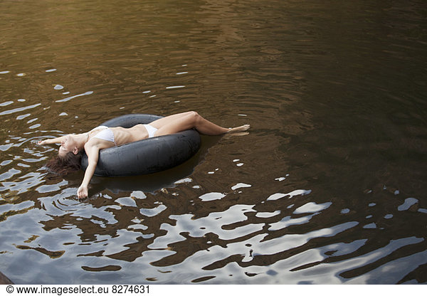 Woman floating in inner tube in river