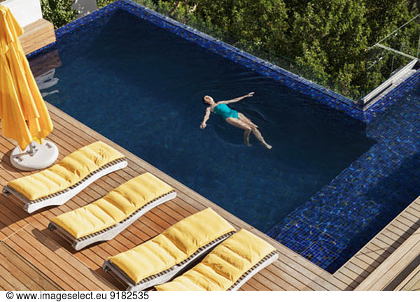 Woman floating in luxury swimming pool