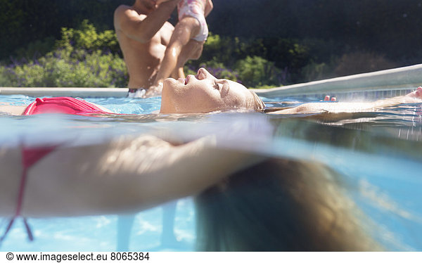 Woman floating in swimming pool