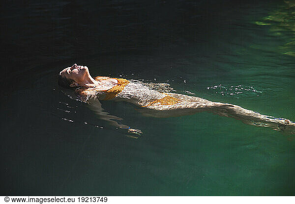 Woman floating on water in river