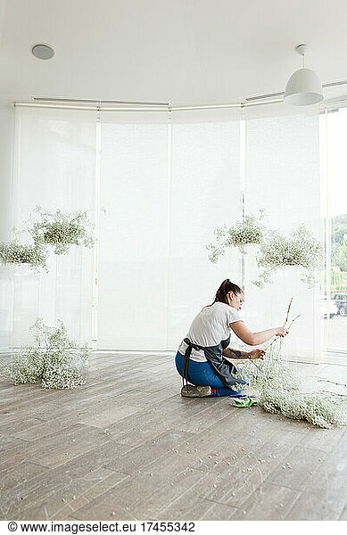 woman florist decorator decorates wedding interior with flowers