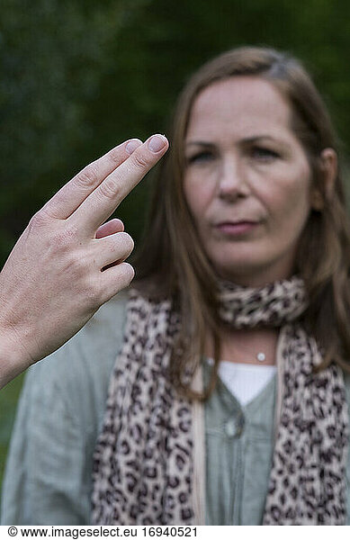 Woman focussing on the hands of a therapist with fingers extended