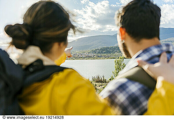 Woman gesturing towards mountains by man