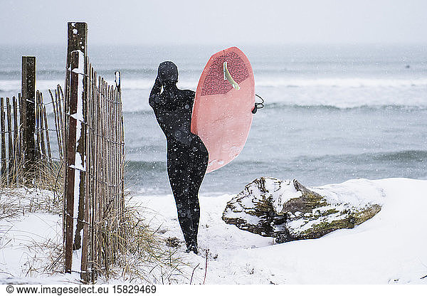 Woman going surfing during winter snow