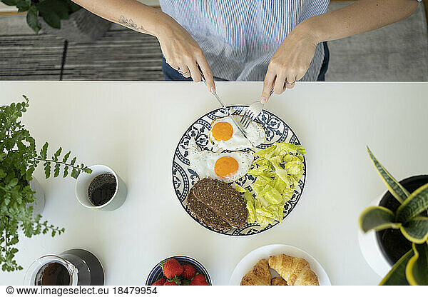 Woman having breakfast at table