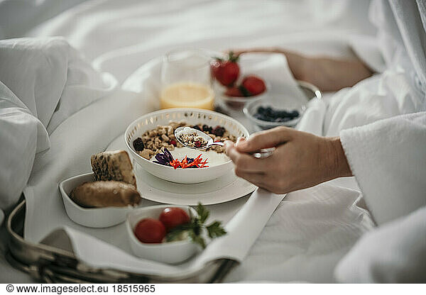Woman having muesli in breakfast at home