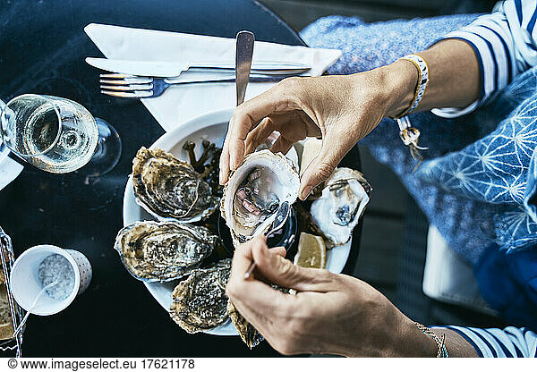 Woman having oysters at table