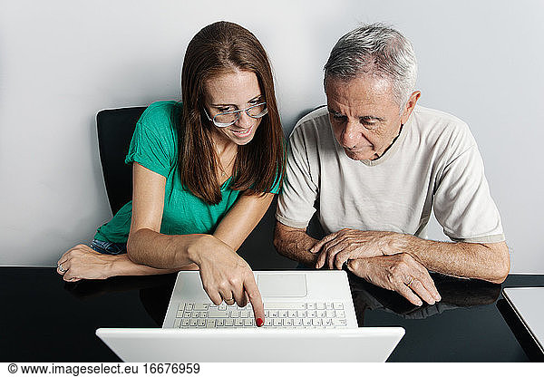 Woman helping father with laptop