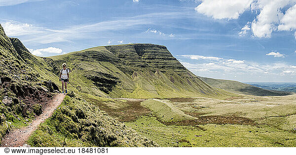 Woman hiking on trail at Fan Brycheiniog on sunny day  Brecon Beacons  Wales
