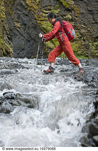 Woman hiking through canyon in Iceland with hiking poles