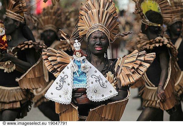 Woman holding a Santo Nino figur at Ati Atihan festival  Ibajay.