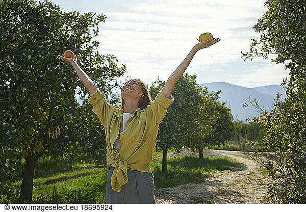 Woman holding citrus fruits in hand at orchard
