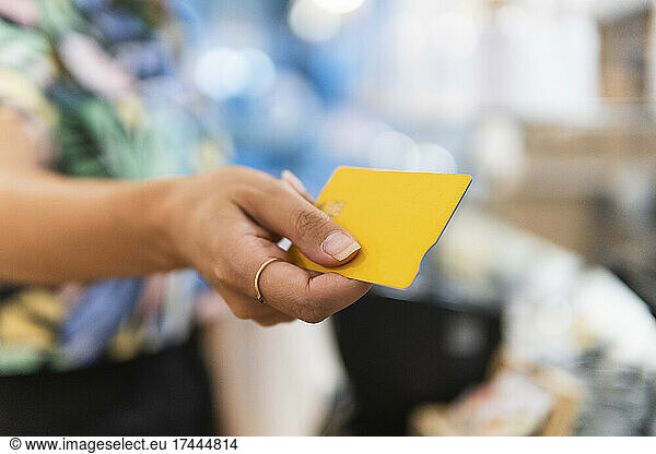Woman holding credit card at restaurant