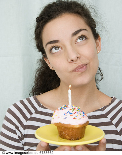 Woman holding cupcake with candle