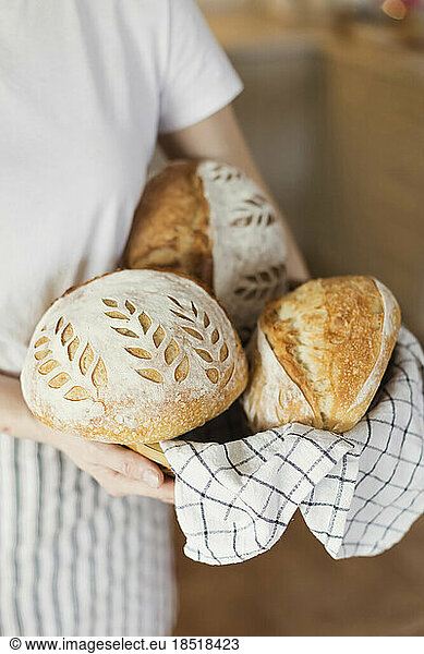 Woman holding freshly baked breads at home