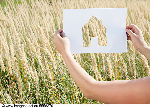 Woman holding paper house cut out