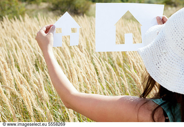 Woman holding paper house cut outs