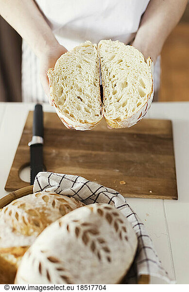 Woman holding sliced sourdough bread at home