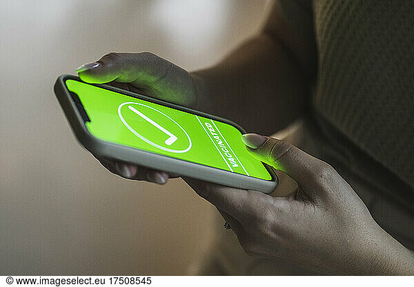 Woman holding smart phone with green check mark symbol on screen