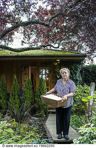 Woman holding towels outside spa building  Galiano Islands  British Columbia  Canada