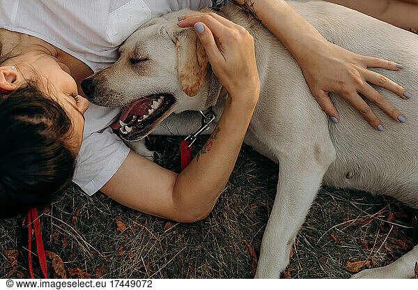 Woman hugging her Labrador outdoors. Lifestyles and pet care concept.