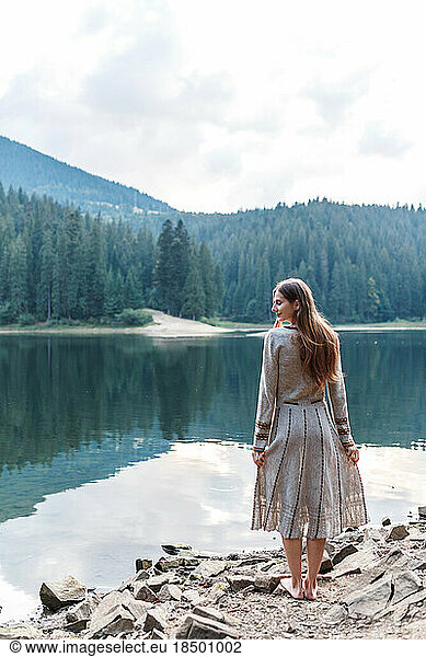 woman in a dress near the lake in the forest in the mountains