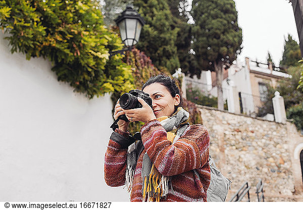 Woman in a sweater taking pictures with a professional camera  Spain