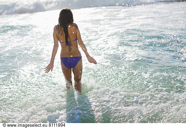 Woman in bikini wading in ocean