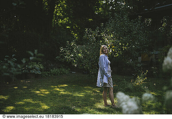 Woman in casual clothing standing on grass in garden