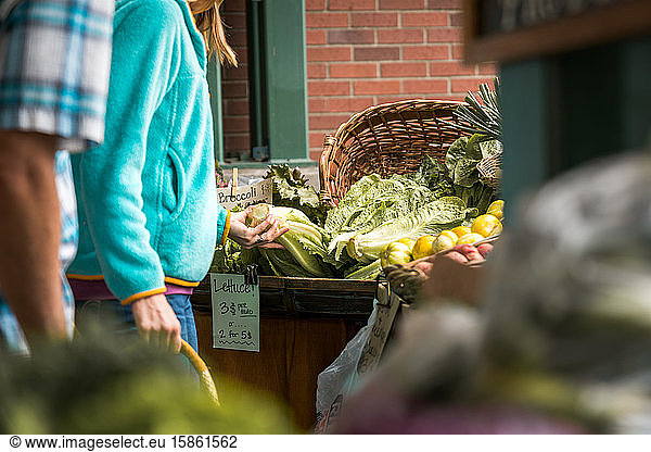 Woman in farmer's market looking at greens