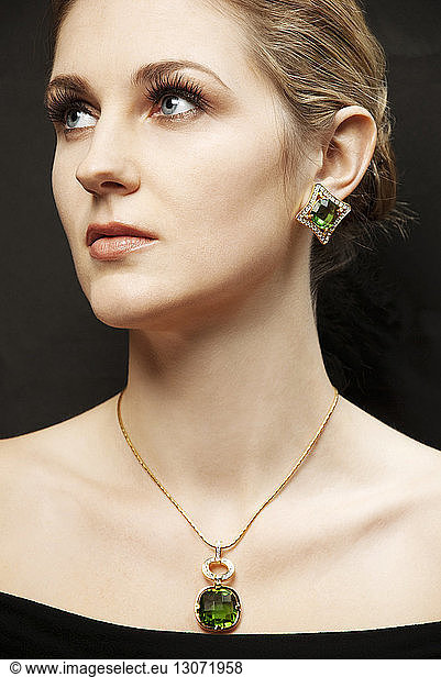 Woman in jewelry against black background