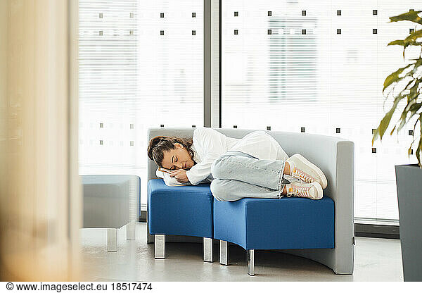 Woman in lab coat sleeping on sofa