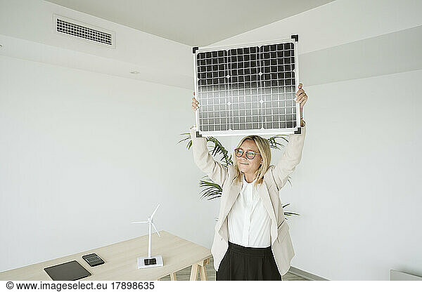 Woman in office holding solar panel