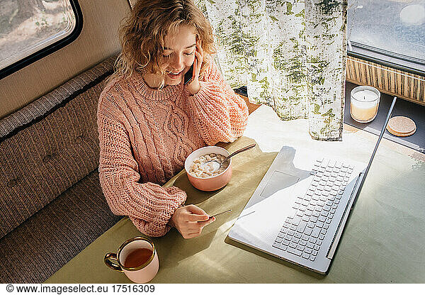 Woman in online shopping trailer behind laptop.