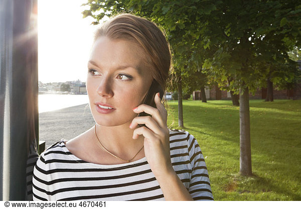 Woman in park talking in telephone