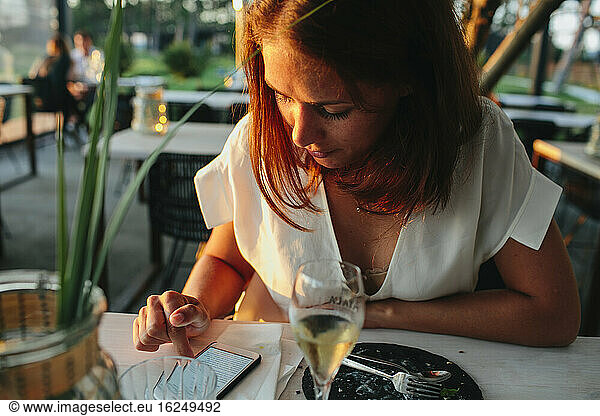 Woman in restaurant using cell phone