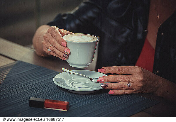 woman is about to drink a cappuccino