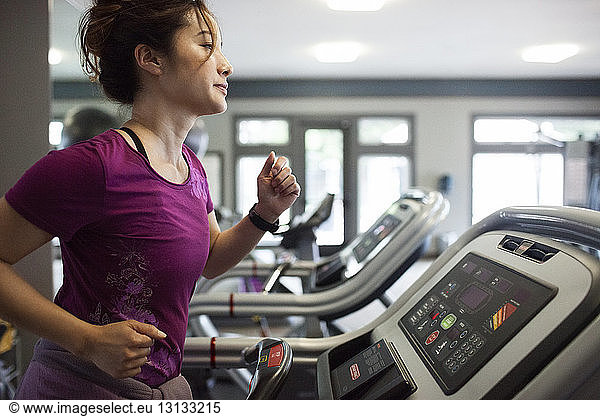 Woman jogging on treadmill at gym