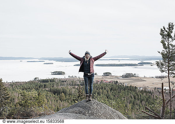 woman jumping for joy as she reaches the top of a hill climbing